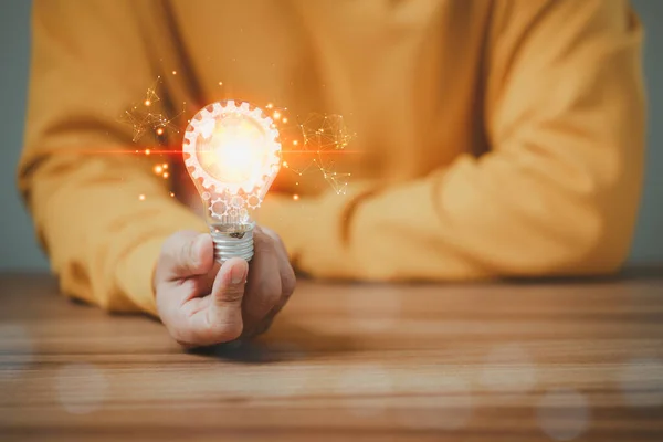 Man touching a bright light bulb. Ideas for presenting new ideas, inspiration in the work and innovation new beginning.