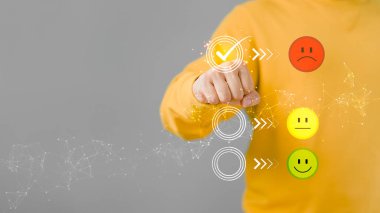 Mutsuz kızgın yüz simgesi üzerindeki sanal ekrana dokunan adam başvurudaki servis deneyimine reyting veriyor. Çevrimiçi müşteri memnuniyet geri bildirim anketi.
