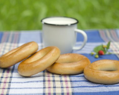 simit ve tartan masa örtüsü üzerinde süt ile kupa