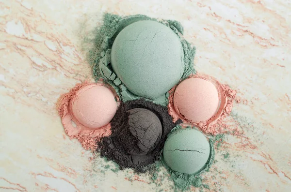 Green (blue), black and pink bentonite clay powder. Clay texture close up. Selective focus. Top view, copy space.