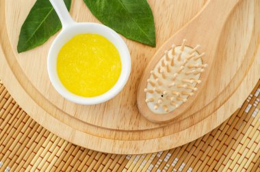 Küçük beyaz bir kase ve ahşap saç fırçasında ev yapımı limon meyve fırçası (maske). Doğal güzellik tedavisi ve spa tarifi. Üst görünüm, alanı kopyala. 