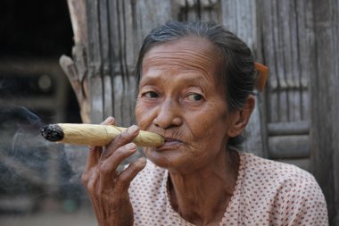 Asiatic woman smoking an handmade cigar clipart