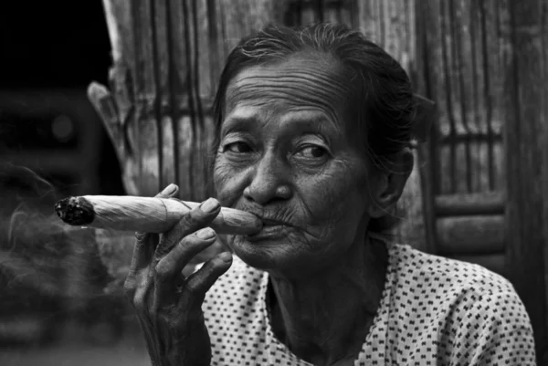 Ασιατική γυναίκα που καπνίζει ένα χειροποίητο πούρο — Φωτογραφία Αρχείου