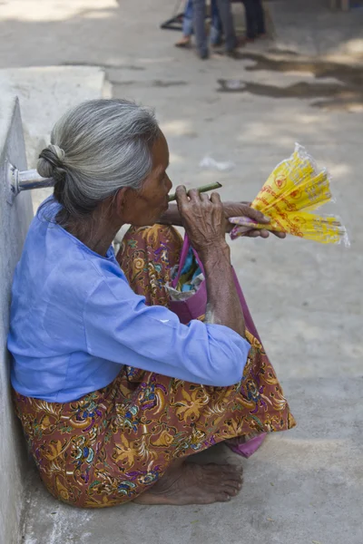 Παλαιά ασιατική γυναίκα που καπνίζει ένα χειροποίητο πούρο — Φωτογραφία Αρχείου
