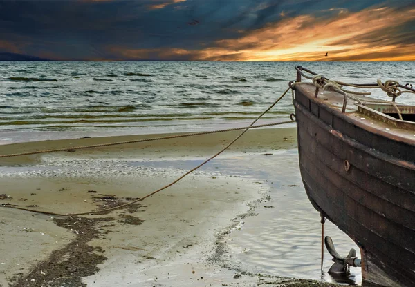 Прибрежный пейзаж со старой рыбацкой лодкой на переднем плане — стоковое фото