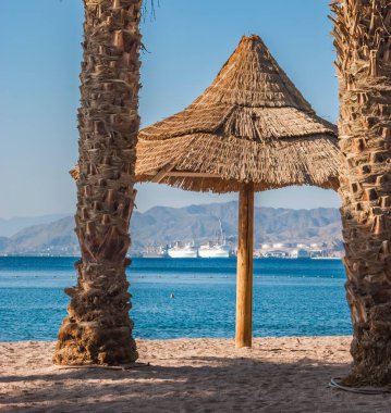 Kızıl Deniz 'in kumlu sahillerindeki Şemsiye, Eilat, İsrail
