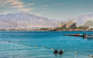 Eilat, İsrail - 04 Mart 2022: Dalgıçlar, Eilat 'ın ünlü turizm beldesi ve Kızıldeniz' de bulunan eğlence amaçlı İsrail kenti yakınlarındaki mercan resiflerine dalmaya hazırlanıyorlar.