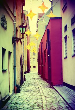 Morning in narrow medieval street of old city of Riga, Latvia. Image toned in vintage warm colors for inspiration of retro style effect