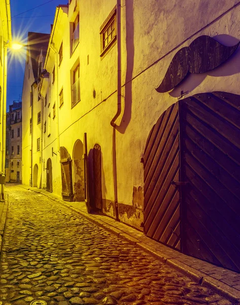 Narrow medieval street at night, old district in European town