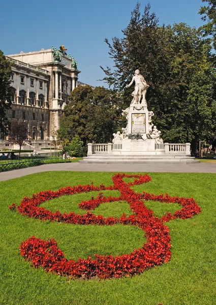 Statue of Amadeus Mozart with flower beds as treble clef in Burg — Stock Photo, Image