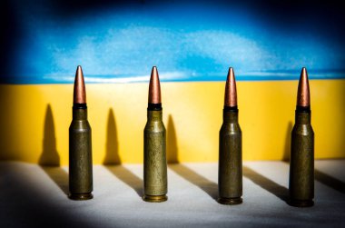 Ukrayna bayrağının arka planında askeri mermilerin soyut görüntüsü (Ukrayna Savaşı - kavram)