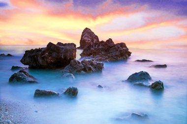 Pitoresk büyülü mistik güzel bir sahne dalgalar ve gün batımında sahilde denizin ortasında taşlar ile. (meditasyon, antistress, gevşeme - kavram)