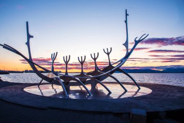 Reykjavik, İzlanda 22 Haziran 2019. Reykjavik, İzlanda 'nın başkenti Reykjavik' te gün batımından sonra bulutlara karşı deniz kenarındaki ünlü Güneş Voyager (Viking gemisi) heykeli..