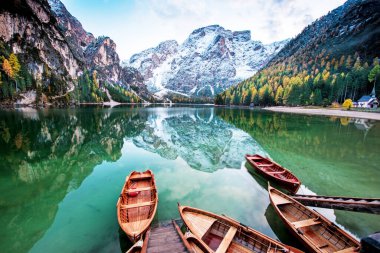 İtalya 'nın güneyindeki Dolomitler' de Fanes-Sennes-Braies gölündeki teknelerin bulunduğu büyülü sonbahar manzarası. (zihinsel tatil, tatil, iç huzur, uyum - konsept)