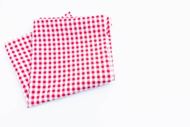 Kırmızı, beyaz damalı kumaş beyaz arka planda katlanmış. Masa örtüsü desenli piknik alanı kopyalama alanı ile izole edilmiş üst görünüm.