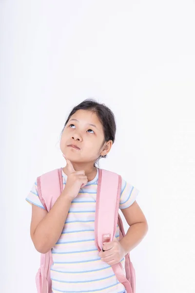 アジアの子供たちの女の子かわいい考え立っている ピンクのバックパックを持つ子供たちは 勉強する準備をするためにコピースペースがある白い背景に学校に行きます 学校のコンセプトに戻る — ストック写真