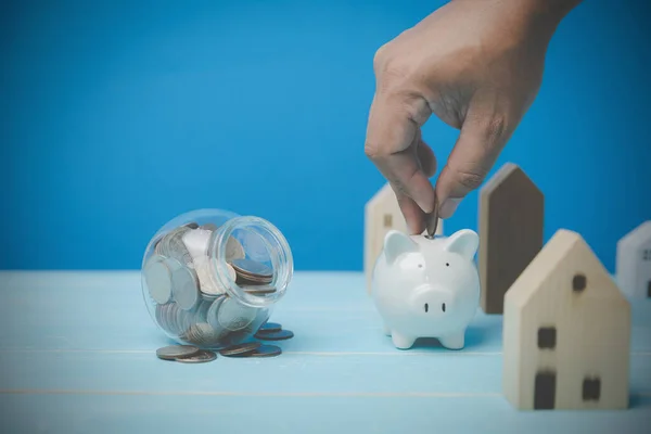 Homem Economiza Dinheiro Para Manter Banco Piggy Branco Para Comprar — Fotografia de Stock