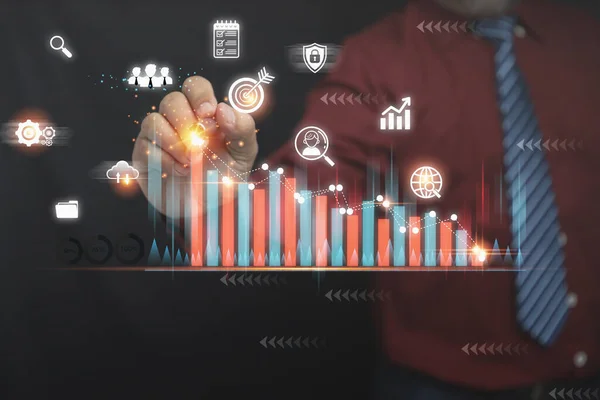 İş finansmanı, muhasebe ve yatırım konsepti. Kalem kullanarak büyüme tablosuna dokunan bir işadamı ve sanal ekranların grafiği ticari yatırım artışının bir sembolüdür.. 