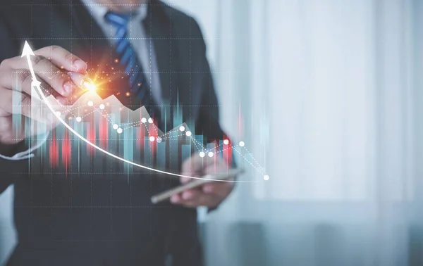 Businessman using a pen touching growth chart and graph virtual screens it is a symbol of business investment growth. Business finance, accounting, and investments concept.