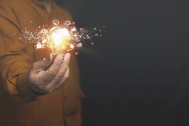 Ampullü yaratıcı fikirler parıldıyor. Elinde ampul tutan bir işadamı ağ bağlantısı hattı ile fikirlerin parıltısını taşıyor. Yaratıcılık tasarımı, yenilik, gelişme, ilham kavramı.