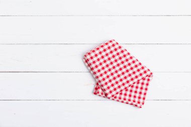 Üst görünüm, düz pamuk kopyalama alanı ile karalanmış. Kumaş kırmızı ve beyaz masa örtüsü beyaz ahşap zemin üzerinde kontrol edildi. 