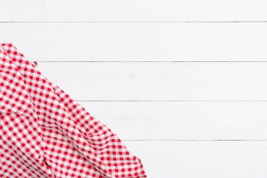 Ahşap beyaz masa üzerinde kırmızı ve beyaz masa örtüsünün üst görüntüsü. Restoranlara metin menüsü için kopyalama alanı olan düz pamuk yatıyordu.