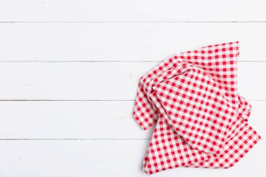 Ahşap beyaz masa üzerinde kırmızı ve beyaz kumaş masa örtüsünün üst görüntüsü. Restoranlara metin menüsü için kopyalama alanı olan düz pamuk yatıyordu. 