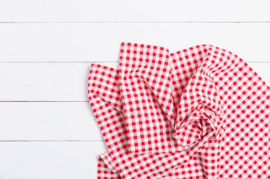 Ahşap beyaz masa üzerinde kırmızı ve beyaz kumaş masa örtüsünün üst görüntüsü. Restoranlara metin menüsü için kopyalama alanı olan düz pamuk yatıyordu. 