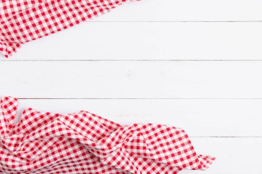 Ahşap beyaz masa üzerinde kırmızı ve beyaz masa örtüsünün üst görüntüsü. Restoranlara metin menüsü için kopyalama alanı olan düz pamuk yatıyordu.