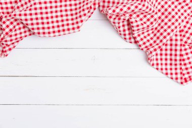 Ahşap beyaz masa üzerinde kırmızı ve beyaz masa örtüsünün üst görüntüsü. Restoranlara metin menüsü için kopyalama alanı olan düz pamuk yatıyordu.