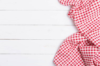 Ahşap beyaz masa üzerinde kırmızı ve beyaz masa örtüsünün üst görüntüsü. Restoranlara metin menüsü için kopyalama alanı olan düz pamuk yatıyordu.