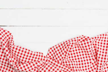Red and white crumpled clothes on white background for a menu of a restaurant with copy space. Top view fabric tablecloth on old white wood background.