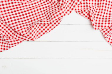 Red and white crumpled clothes on white background for a menu of a restaurant with copy space. Top view fabric tablecloth on old white wood background.