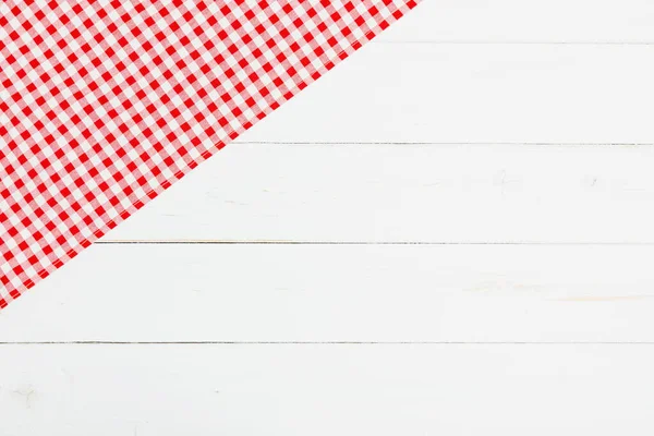 Clothes red and white on white background for a menu of a restaurant with copy space. Top view fabric tablecloth on old white wood background. Flat lay checked fabric old wooden.