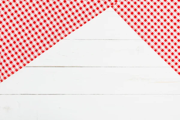 Red and white clothes on white background for a menu of a restaurant with copy space. Top view fabric tablecloth on old white wood background.