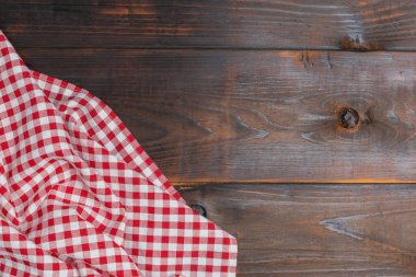 Checkered red and white on an old wooden background with copy space, flat lay, top view. Top view textile a checkered red and white on the table wood.