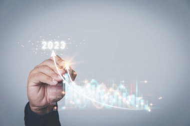 Yıl 2023. El Adam, fotokopi uzayı ile sanal ekrana dokunmak için bir kalem kullanıyor. Planlama stratejisi yatırımı ve pazarlamayı hisse senetlerine analiz etmek. İş, Yatırım ve finansal kavramlar.