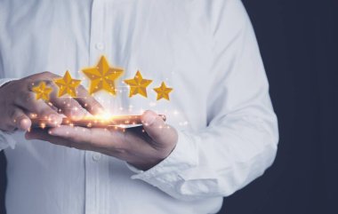 Müşteri hizmetleri değerlendirmesi ve tatmin konsepti. Bir iş adamı, akıllı telefon değerlendirmesini beş yıldızlı memnuniyet için kullanıyor. Popüler servisi derecelendiriyorum.