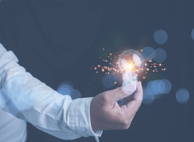 İş adamı elinde fotokopi alanı olan parlak bir ampul tutuyor. Geleceğin yenilik teknolojisi. Geleceğe büyümek için iş yapma fikri.