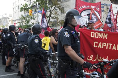 Toronto, Ontario, Kanada - 06 / 25 / 2010: Polis, G20 zirvesi öncesinde düzenlenen protestoda Üniversite Bulvarı boyunca yürüyen binlerce eylemciyi kontrol etmek için bisikletleri kullandı