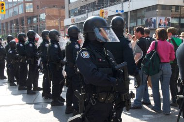 Toronto, Ontario, Kanada - 06 / 25 / 2010: Toronto şehir merkezindeki College caddesi boyunca G20 zirvesi öncesinde düzenlenen protestoya katılan çevik kuvvet polislerinin görevlendirilmesi