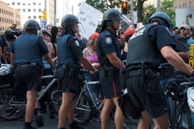 Toronto, Ontario, Kanada - 06 / 25 / 2010: Polis, G20 zirvesi öncesinde düzenlenen protestoda Üniversite Bulvarı boyunca yürüyen binlerce eylemciyi kontrol etmek için bisikletleri kullandı