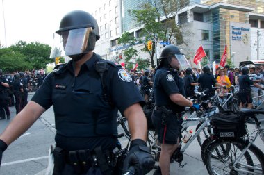 Toronto, Ontario, Kanada - 06 / 25 / 2010: Polis, G20 zirvesi öncesinde düzenlenen protestoda Üniversite Bulvarı boyunca yürüyen binlerce eylemciyi kontrol etmek için bisikletleri kullandı