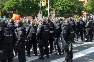 Toronto, Ontario, Kanada - 06 / 25 / 2010: G20 zirvesi öncesinde düzenlenen protestoda Üniversite Bulvarı boyunca yürüyen binlerce eylemciyi kontrol etmek için çevik kuvvet tam teçhizat