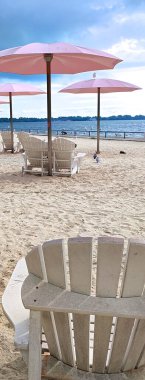 Sıcak bir yaz gününde şehirde pembe şemsiyeli bir plaj parkının internet afişi.