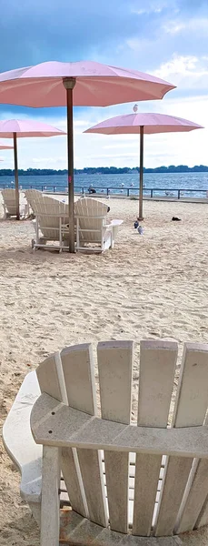 Sıcak bir yaz gününde şehirde pembe şemsiyeli bir plaj parkının internet afişi.