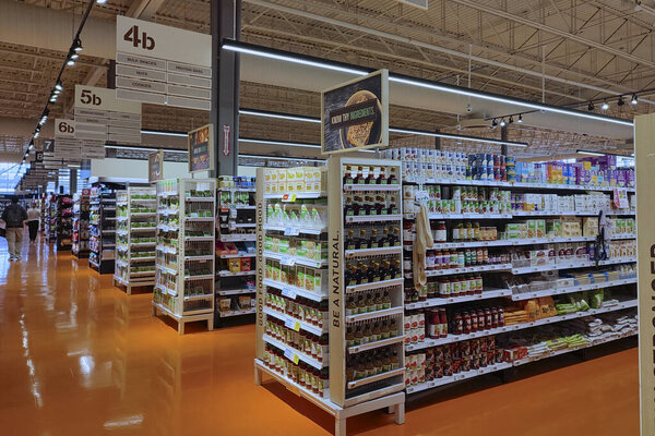 Toronto, Canada - 09-22-2022: Diminishing perspective view of shelves with merchandise in the supermarket.