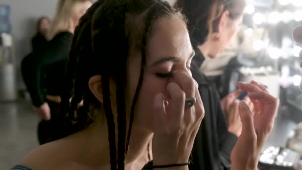 Backstage scene: Models do a make-up and hairstyle before start a fashion show. — Stock Video