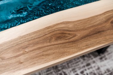 Meşe ağacı mavi renkli epoksi reçineyle birleştirilir. sehpa