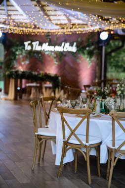 Beyaz yastıklı tahtadan yapılmış doğal sandalyeler. Şenlik Salonu